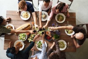 Pessoas reunidas em volta de uma mesa comemorando